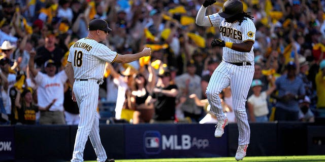 Josh Bell #24 of the San Diego Padres celebrates with third base coach Matt Williams #18 as he rounds the bases after hitting a home run in the second inning of Game 2 of the NLCS between the Philadelphia Phillies and the San Diego Padres Diego at Petco Park on October 19, 2022 in San Diego, California.
