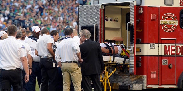 El ala defensiva de los Denver Broncos, Derek Wolfe (95), es cargado en la ambulancia después de sufrir una lesión en el primer cuarto contra los Seattle Seahawks el 17 de agosto de 2013 en el CenturyLink Field. 