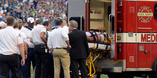 El ala defensiva de los Denver Broncos, Derek Wolfe (95), es cargado en la ambulancia después de sufrir una lesión en el primer cuarto contra los Seattle Seahawks el 17 de agosto de 2013 en el CenturyLink Field. 