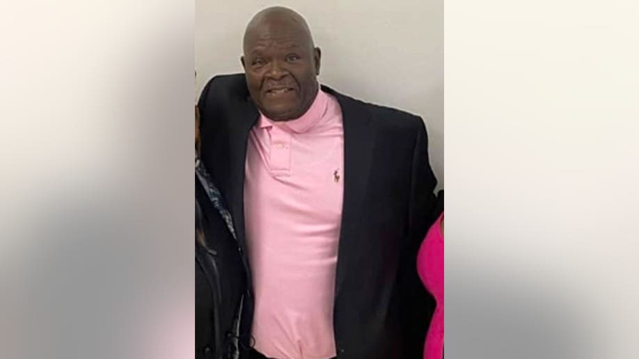 Mike Hill in a pink polo and black blazer posing for a photo.