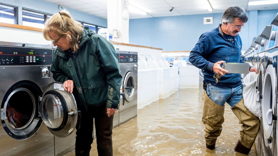 A man and woman in a flooded Pajaro laundromat