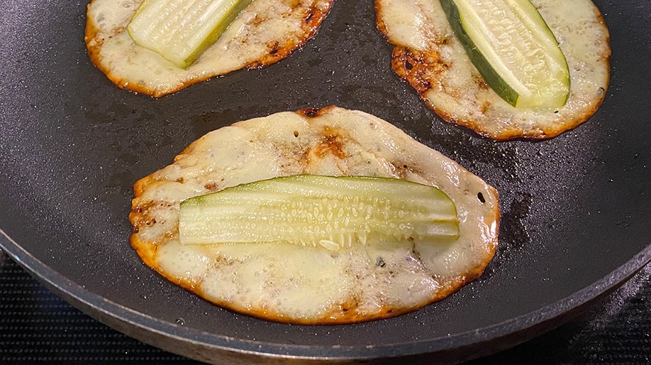 Three pickle slices placed in the center of fried provolone cheese