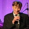 Bobby Caldwell singing into a microphone while on stage