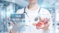 A closeup of a doctor working with the patient digital medical card or digital heart treatment structure on the touch screen at the hospital interior background.