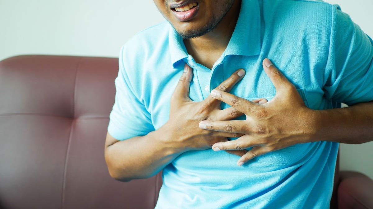 Man grasping at his chest from pain.