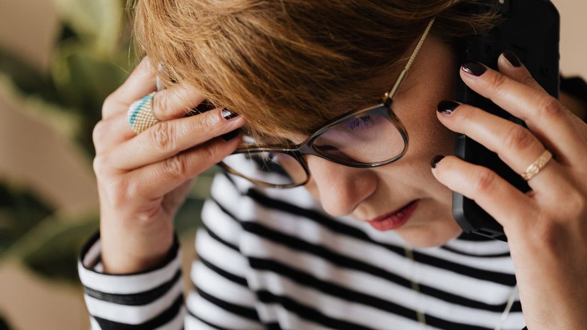 Woman visibly upset on the phone.