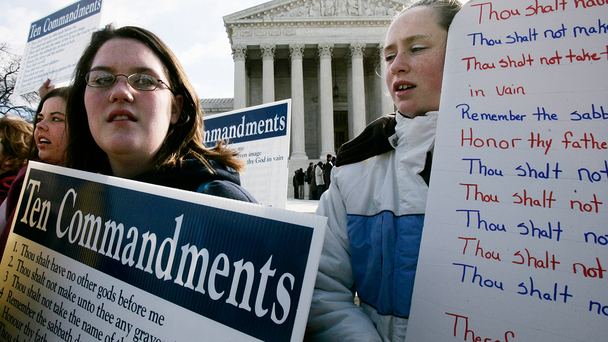 Anna Dollar (2nd L) of Boone, NC, and Deanna Gosnell (R) of Avery, North Carolina, hold posters during a rally in front of the U.S. Supreme Court to support the Ten Commandments March 2, 2005 in Washington, DC. The Supreme Court heard two cases on whether Ten Commandments monuments should be displayed on government properties.