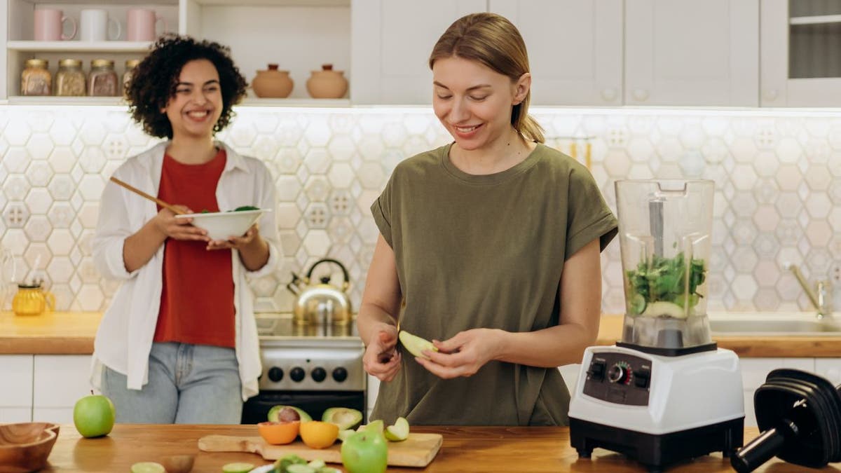 A group of friends conversing in a kitchen setting 