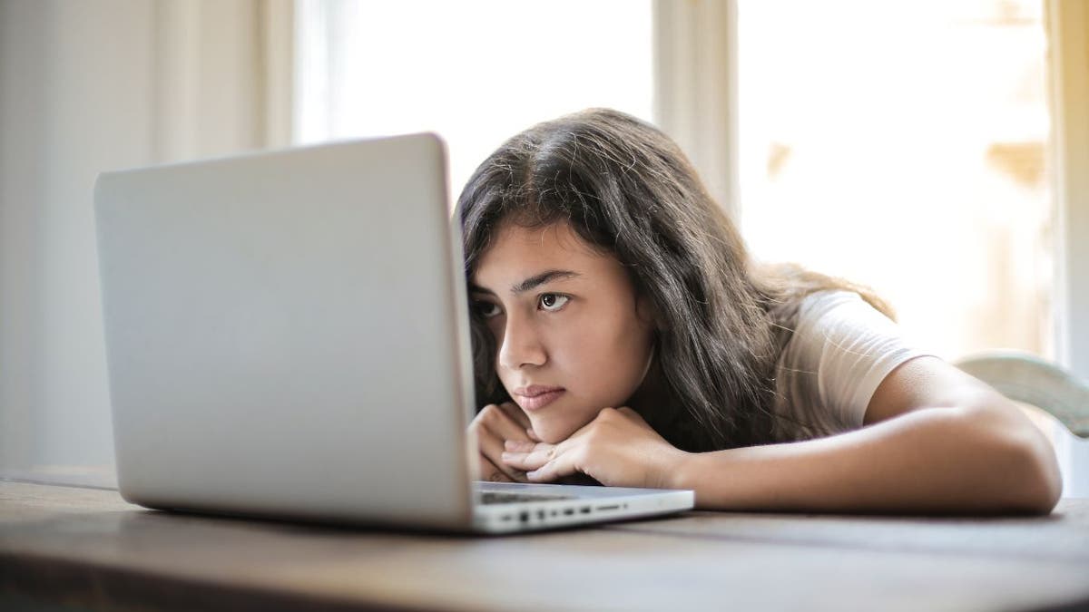 Woman with her head down on her laptop.