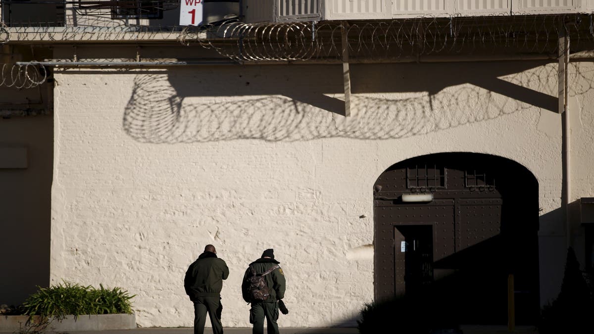 Prison guards walk in yard