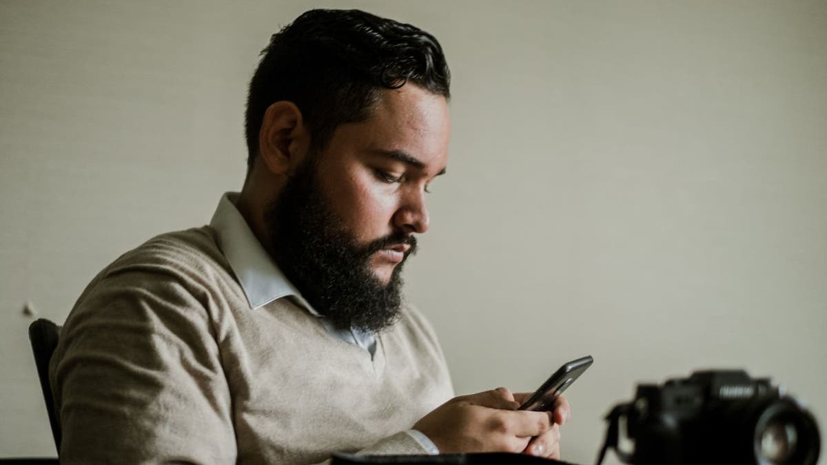 Man looks down at his phone