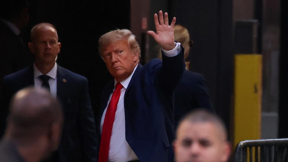 Donald Trump waves at supporters on New York City street