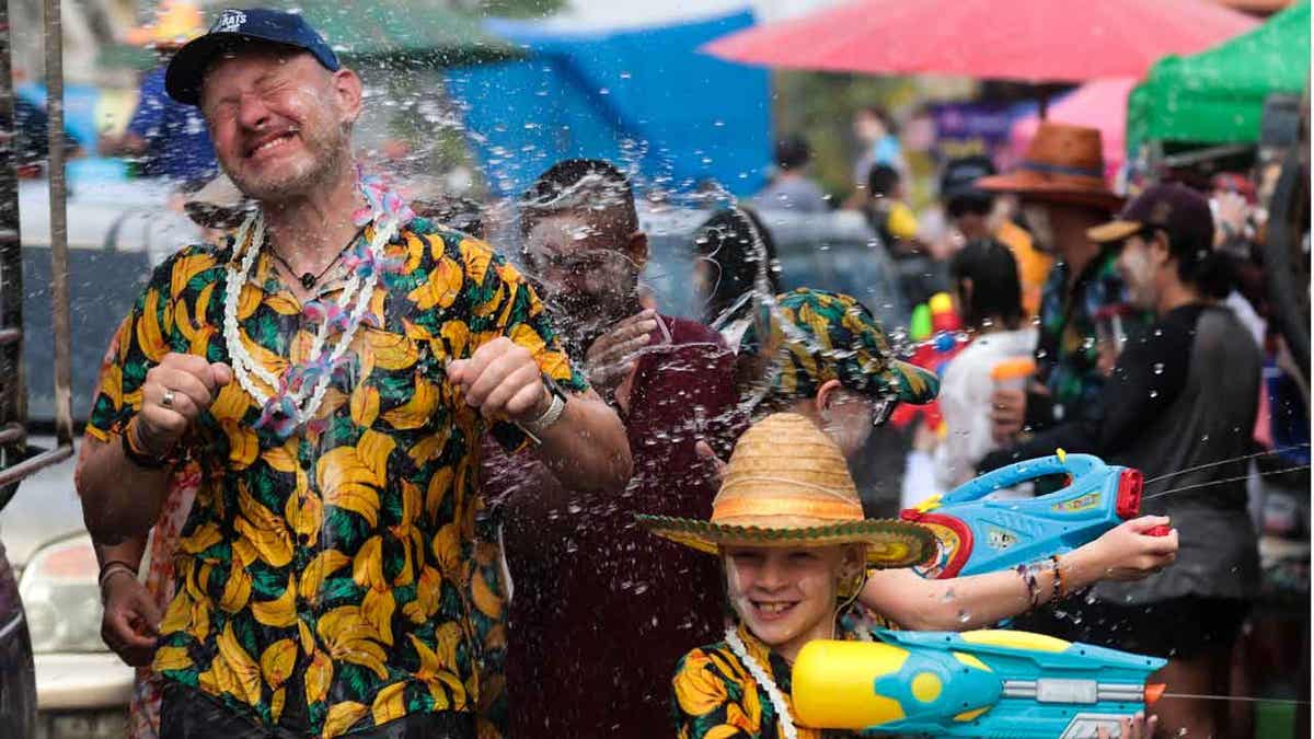 A man sprays water at western tourists 