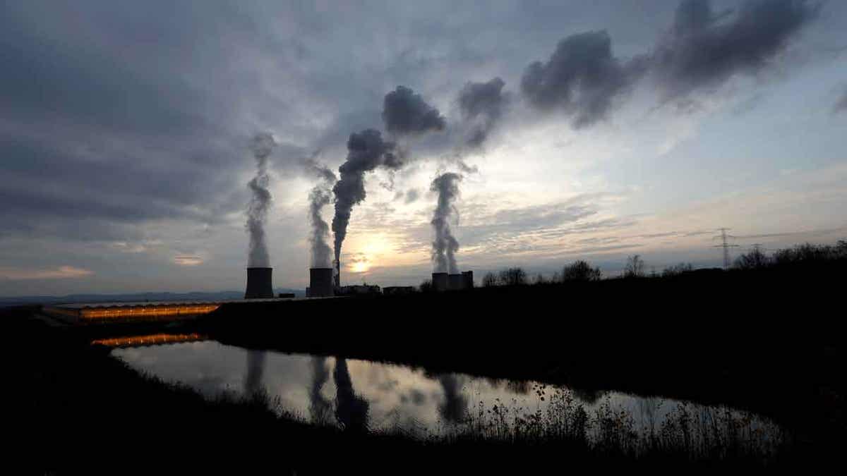 smoke rises from chimneys at power plant