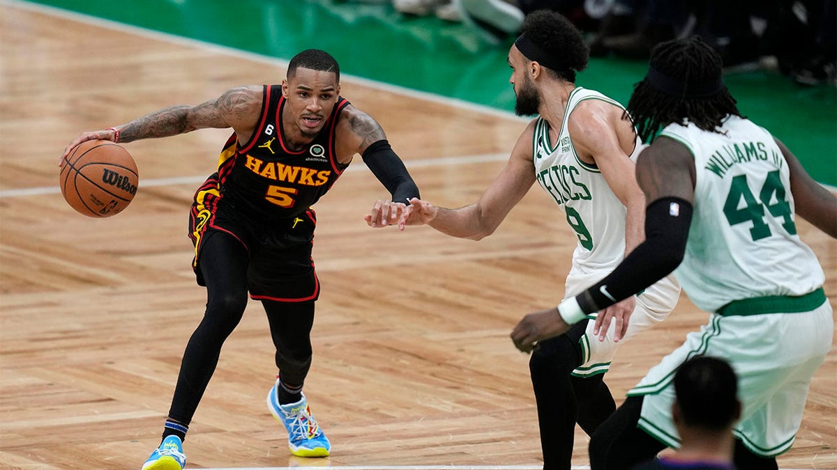 Dejounte Murray drives against the Celtics