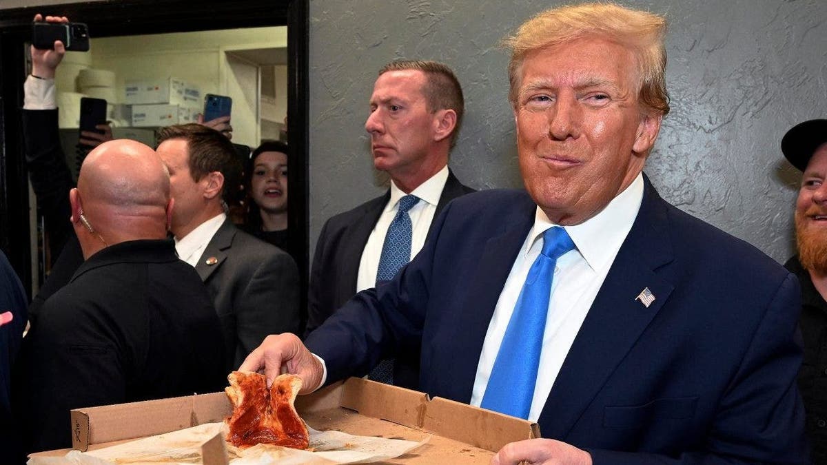 Former President Donald Trump eats a slice of pizza in Florida