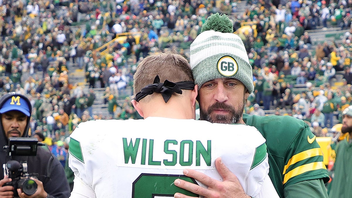 Aaron Rodgers and Zach Wilson embrace