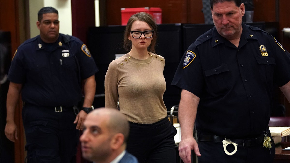 Anna Delvey wearing a stylish beige sweater in court 