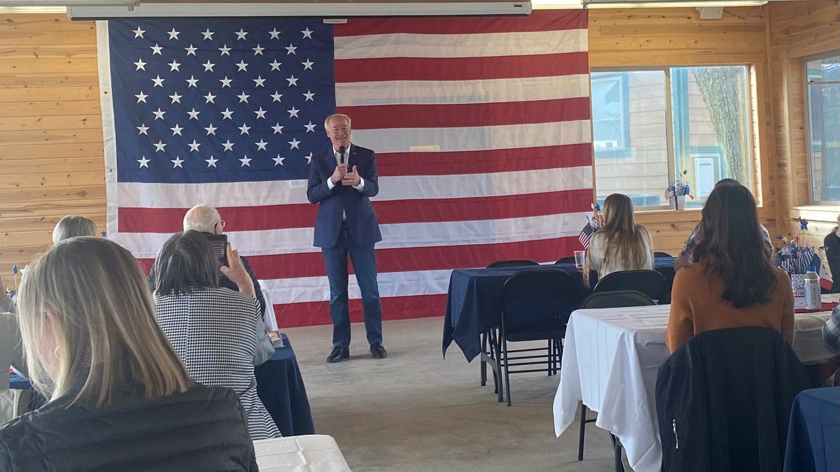 Asa Hutchinson in Iowa with US flag behind him