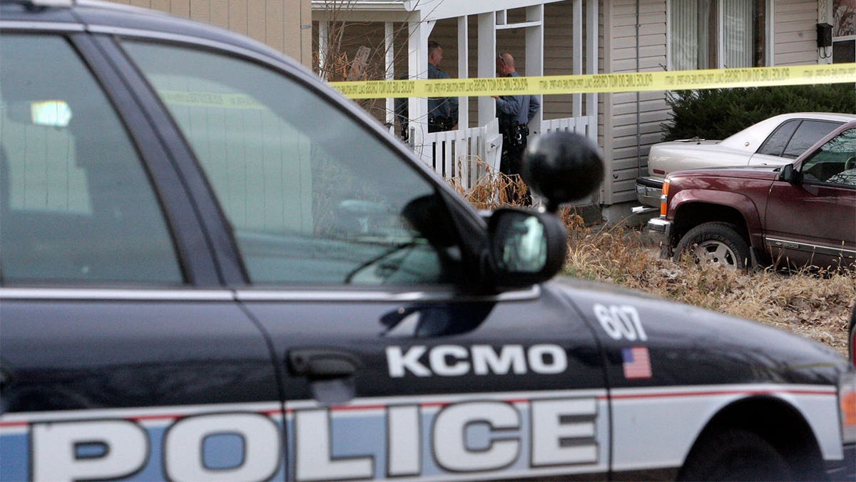 Police standing at the porch of a house.