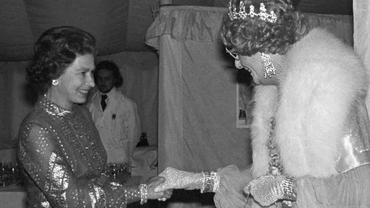 Britain's Queen Elizabeth II, left, shakes hands with Barry Humphries Dame Edna Everage