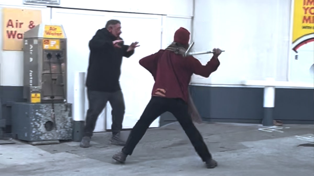 A man swings a pipe at another man outside a gas station