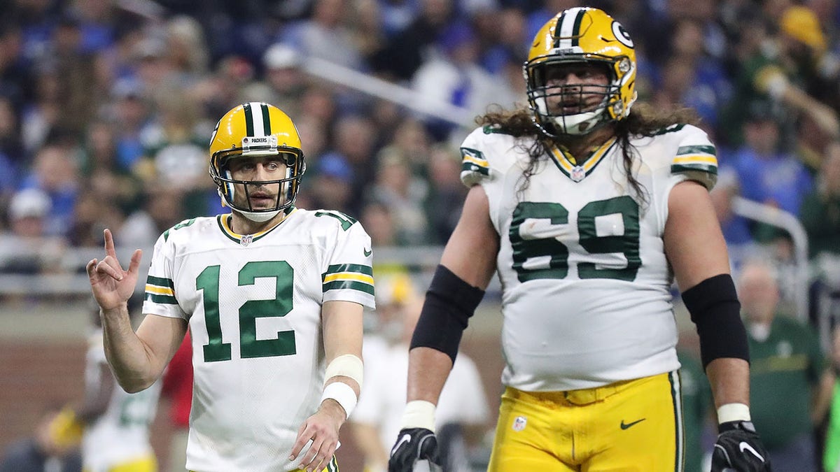 Aaron Rodgers and David Bakhtiari walk on the football field