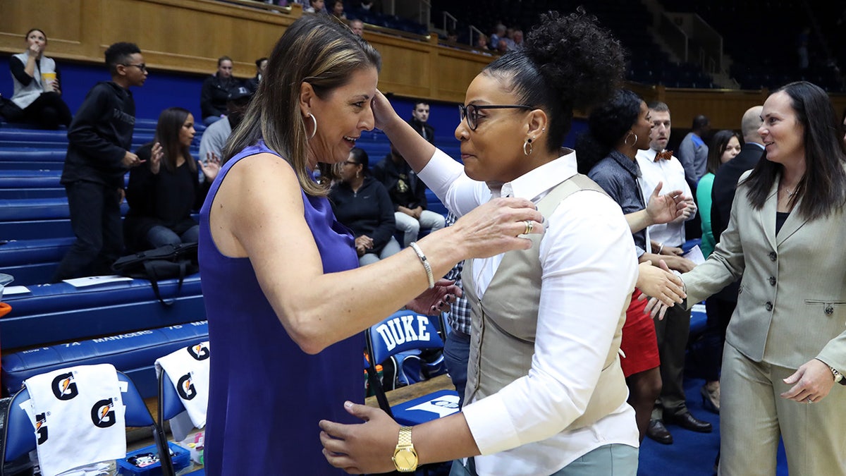 Coach DeUnna Hendrix hugs another coach