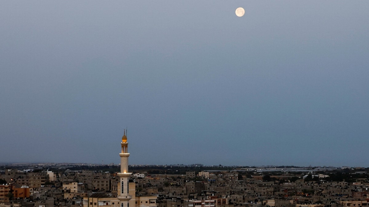 The moon appears in the sky in the southern Gaza Strip