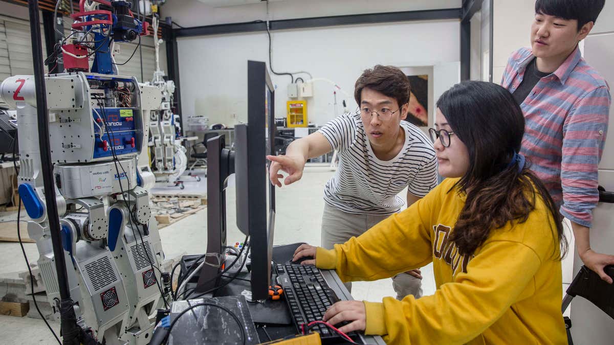 Students at a university in Seoul scan AI software for humanoid robots at a special research center
