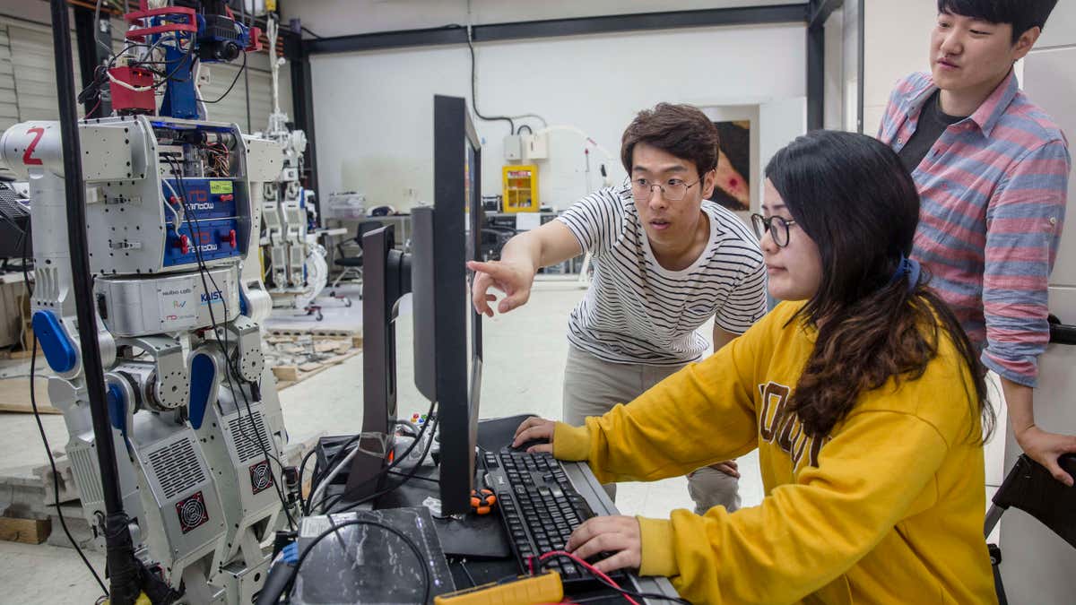 Students at a university in Seoul scan AI software for humanoid robots at a special research center