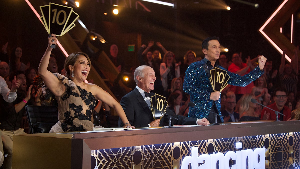 Carrie Ann Inaba, Len Goodman, and Bruno Tonioli all hold up '10' paddles while on the set of "Dancing with the Stars"