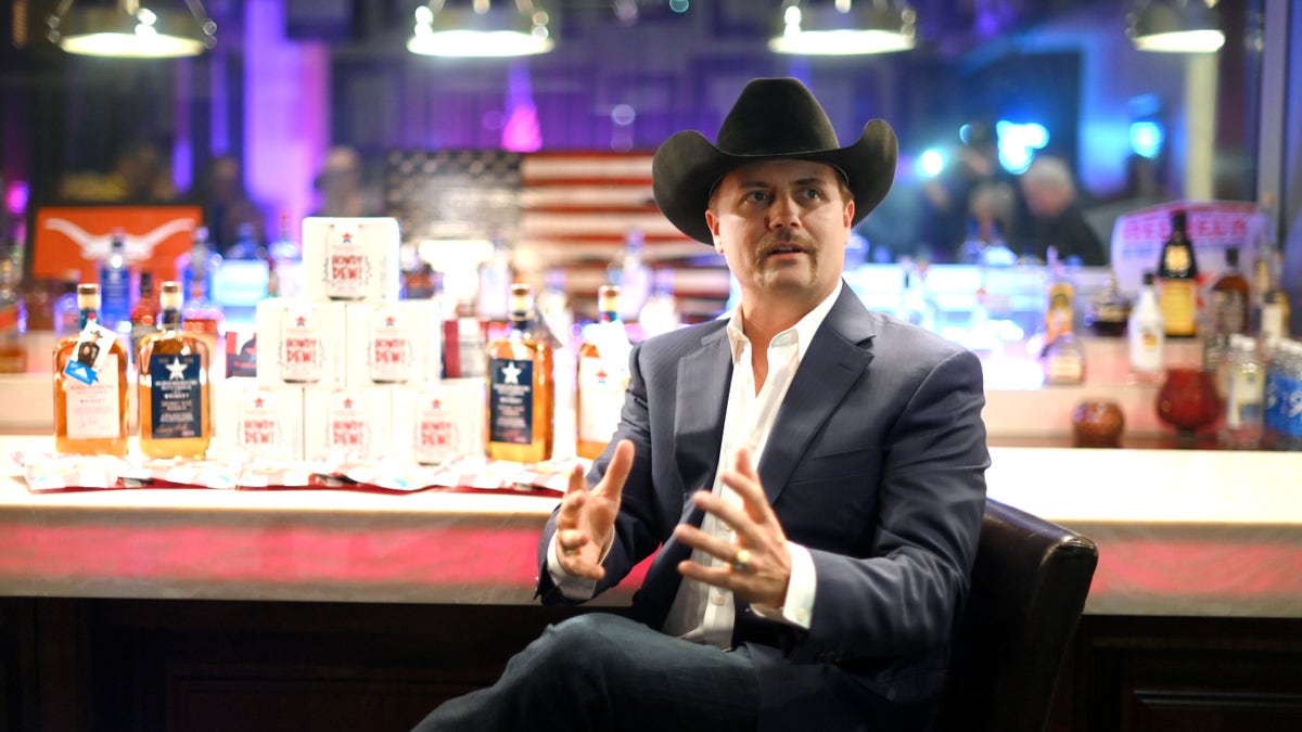 John Rich sits at a bar in a cowboy hat