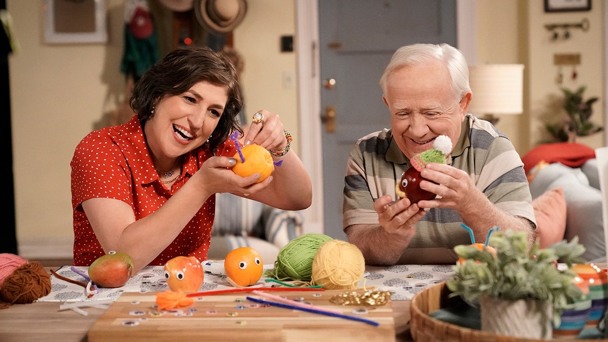 Mayim Bialik and Leslie Jordan in "Call Me Kat" as characters Kat and Phil, decorating fruit