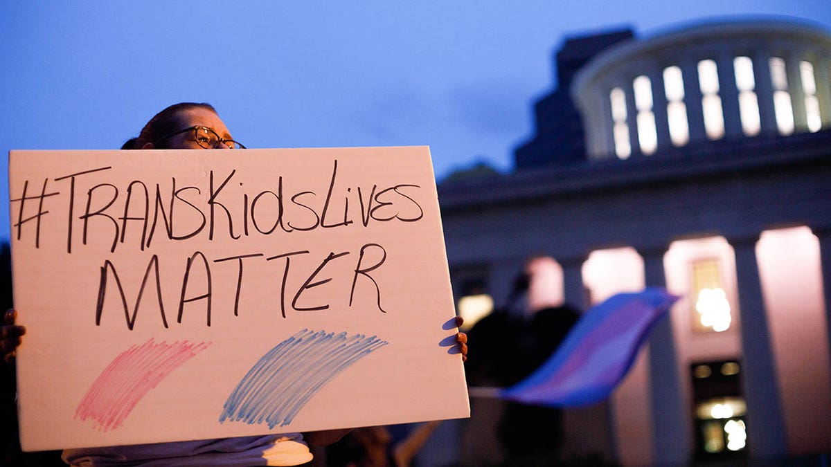 Transgender rights protester holds sign