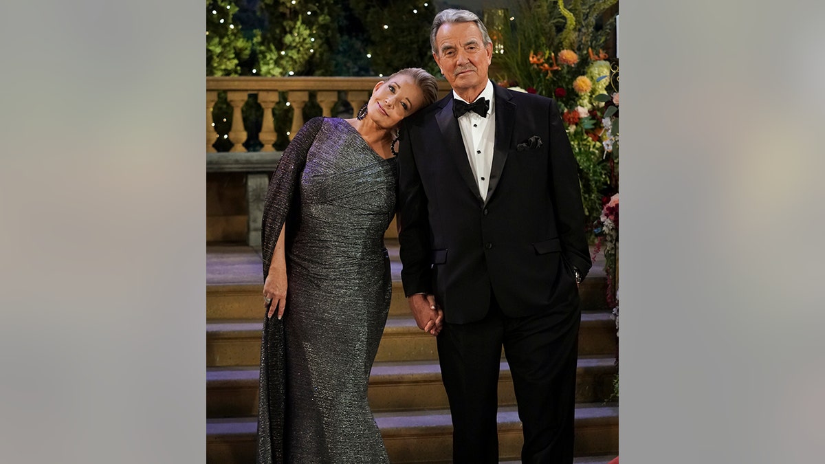 Melody Thomas Scott as Nikki Newman in a sparkly dress leans her head against Eric Braeden as Victor Newman in a classic black tuxedo in an episode of "The Young and the Restless"