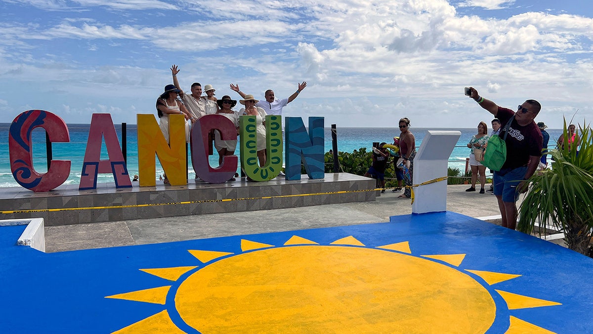 Cancun sign with tourist posing