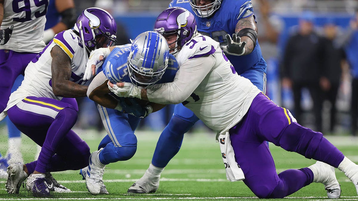 Amon-Ra St. Brown gets tackled during a game against Minnesota