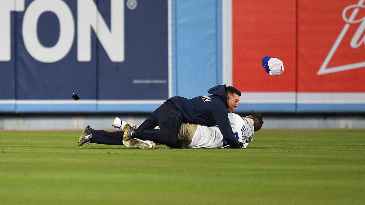 A Dodgers fan is tackled by security