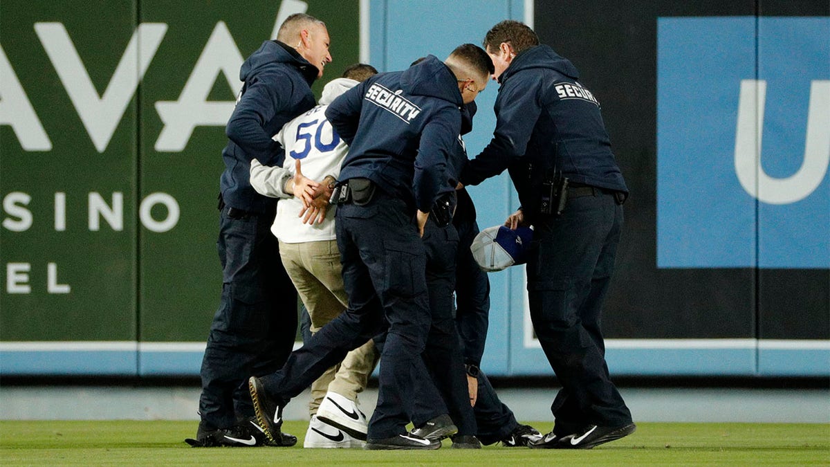 Security personnel remove a Dodgers fan