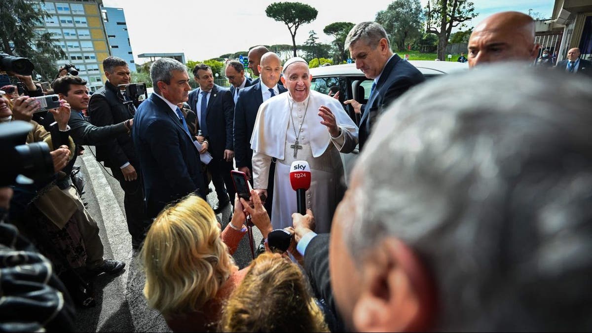 Pope Francis speaks with reporters after leaving the hospital in Rome