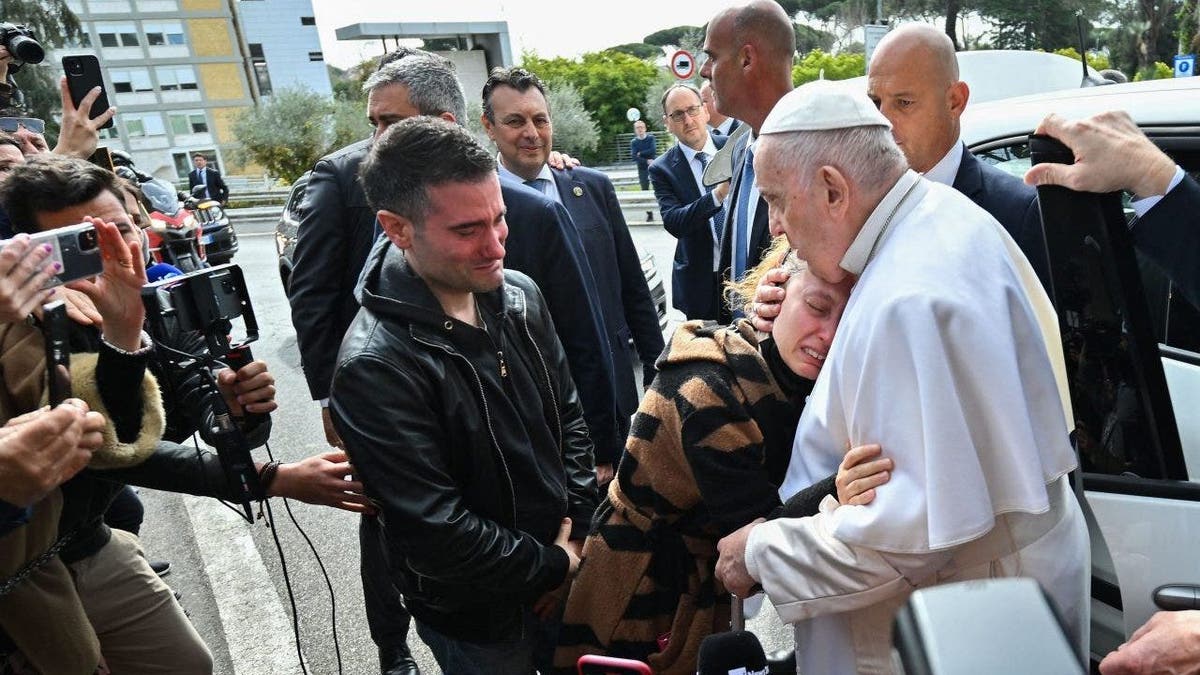 Pope Francis hugs woman after leaving hospital