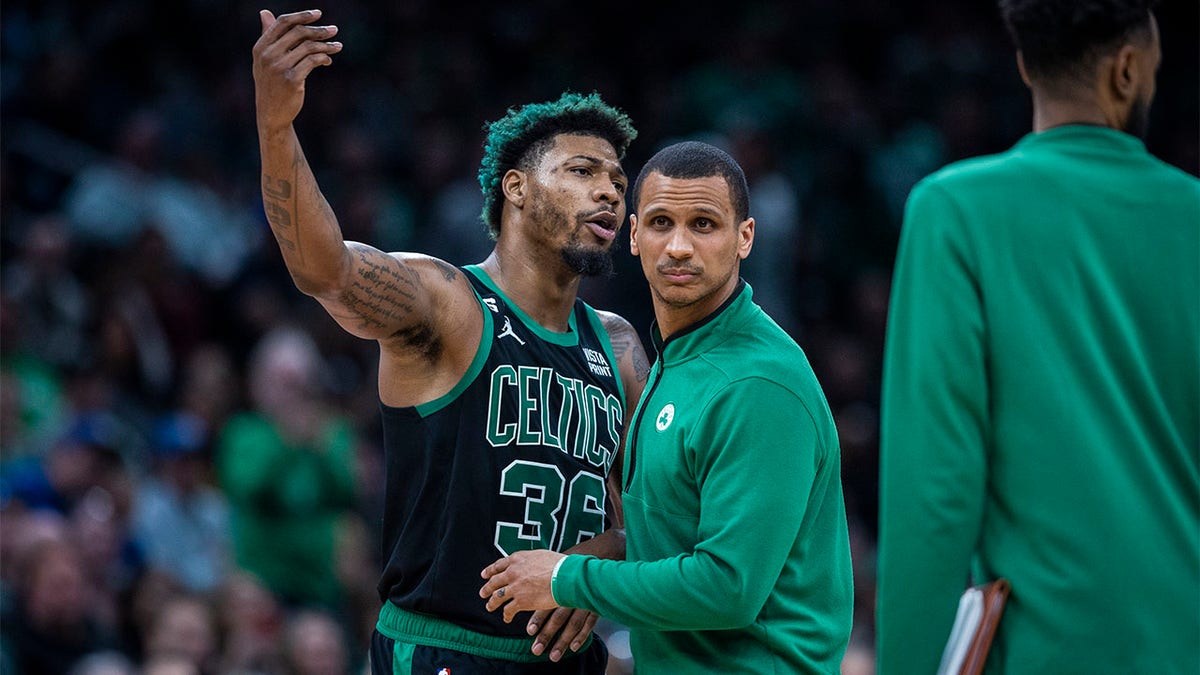 Marcus Smart is held back by Joe Mazzulla