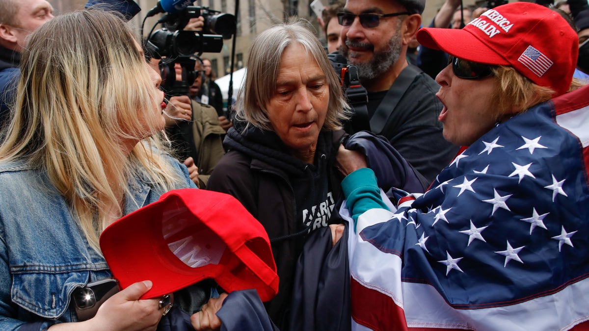 NEW YORK, NY - APRIL 04: Trump supporters argues with an Anti-Trump protester (C) after they removed an anti-Trump banner from her outside the Manhattan Criminal Courthouse on April 04, 2023 in New York City. Former President Donald Trump is scheduled to travel to New York City today with an expected arraignment tomorrow at court following his indictment by a grand jury. The indictment is sealed but a grand jury has heard evidence of money paid to adult film actress Stormy Daniels during Trump's 2016 presidential campaign. (Photo by Kena Betancur/Getty Images)