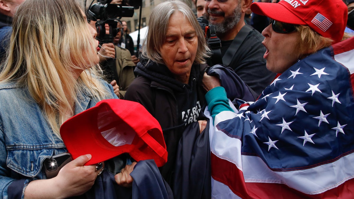 NEW YORK, NY - APRIL 04: Trump supporters argues with an Anti-Trump protester (C) after they removed an anti-Trump banner from her outside the Manhattan Criminal Courthouse on April 04, 2023 in New York City. Former President Donald Trump is scheduled to travel to New York City today with an expected arraignment tomorrow at court following his indictment by a grand jury. The indictment is sealed but a grand jury has heard evidence of money paid to adult film actress Stormy Daniels during Trump's 2016 presidential campaign. (Photo by Kena Betancur/Getty Images)