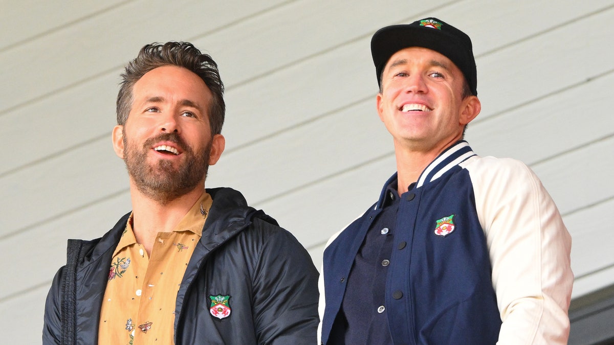 Ryan Reynolds and Rob McElhenney watch a soccer game from the stands