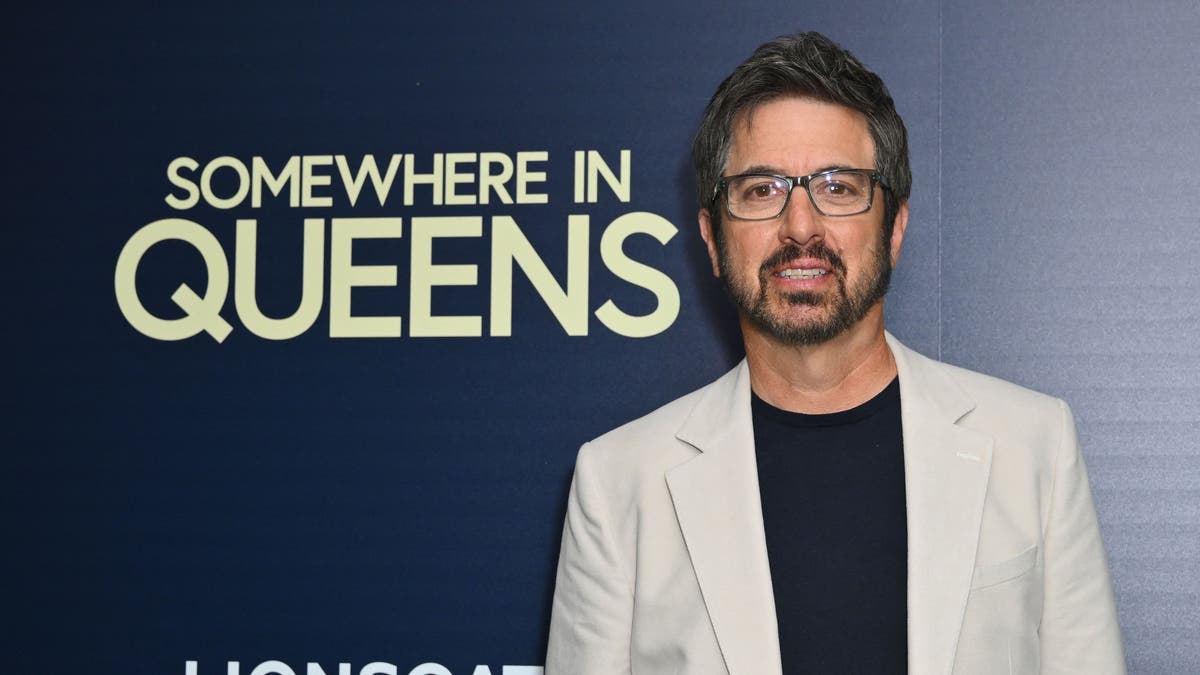 Ray Romano in front of signage for his movie "Somewhere in Queens."