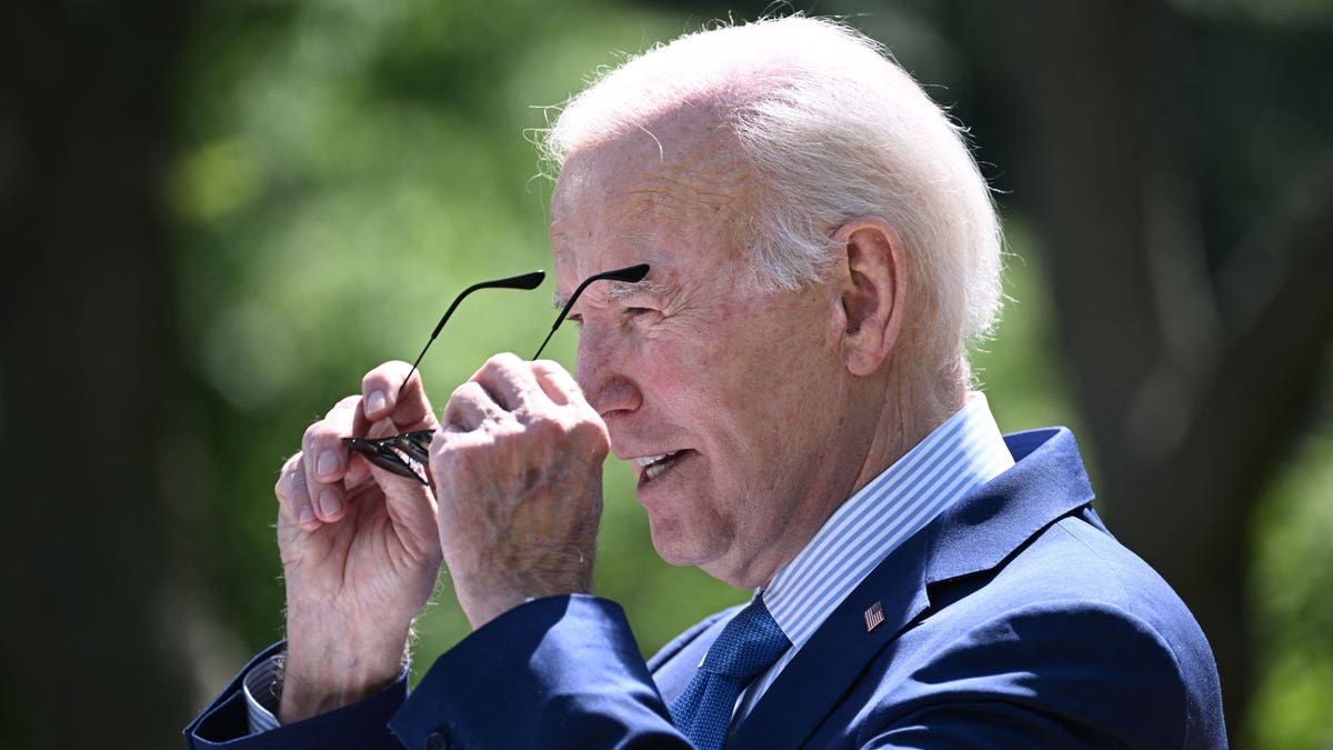 President Joe Biden putting on sunglasses