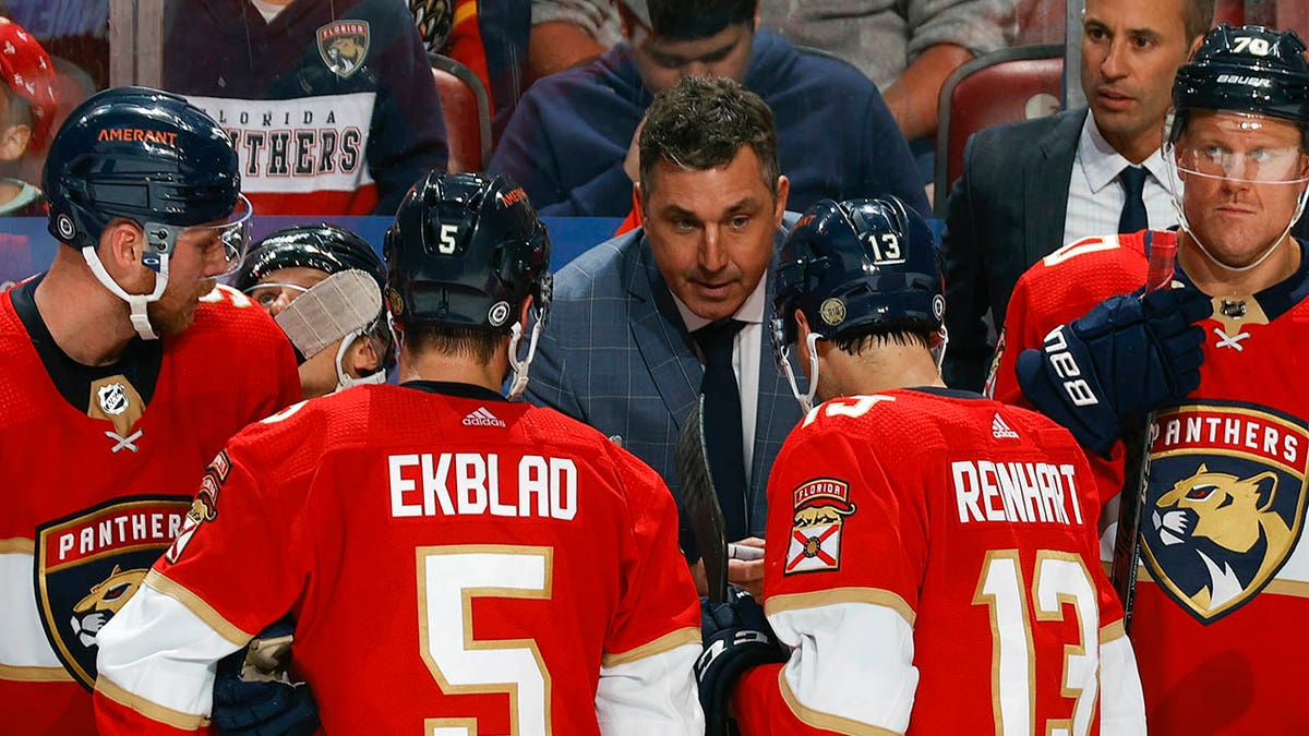 Andrew Brunette speaks to players on the bench during a Panthers game