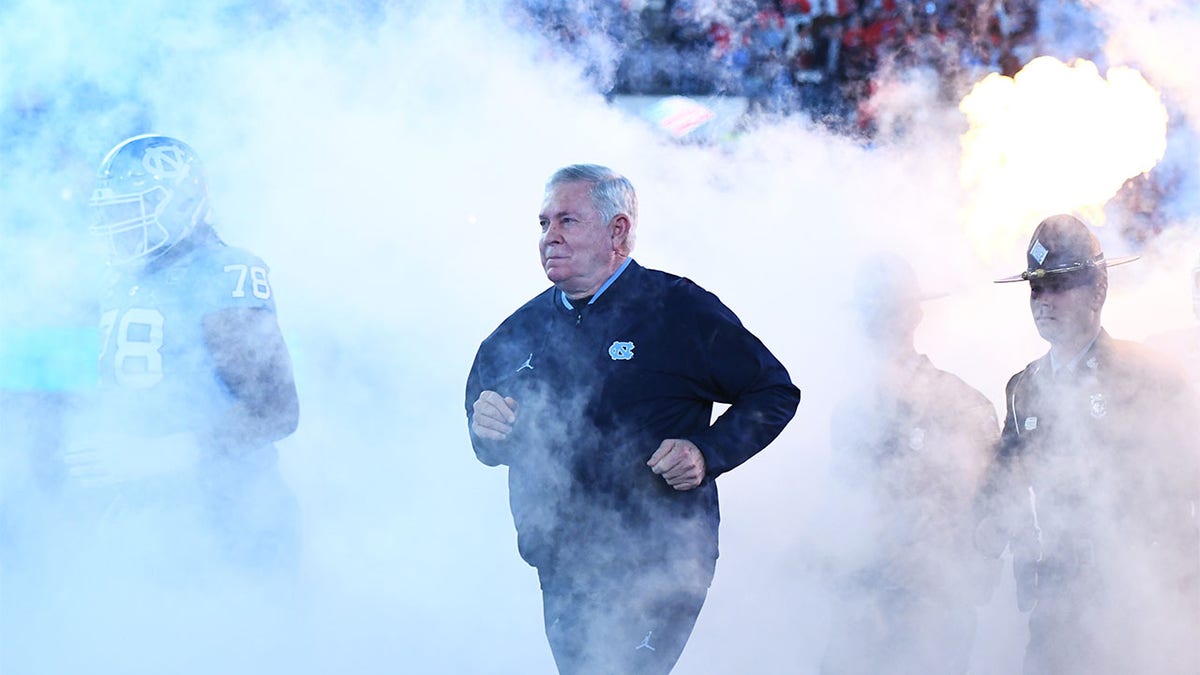 Mack Brown runs onto the field